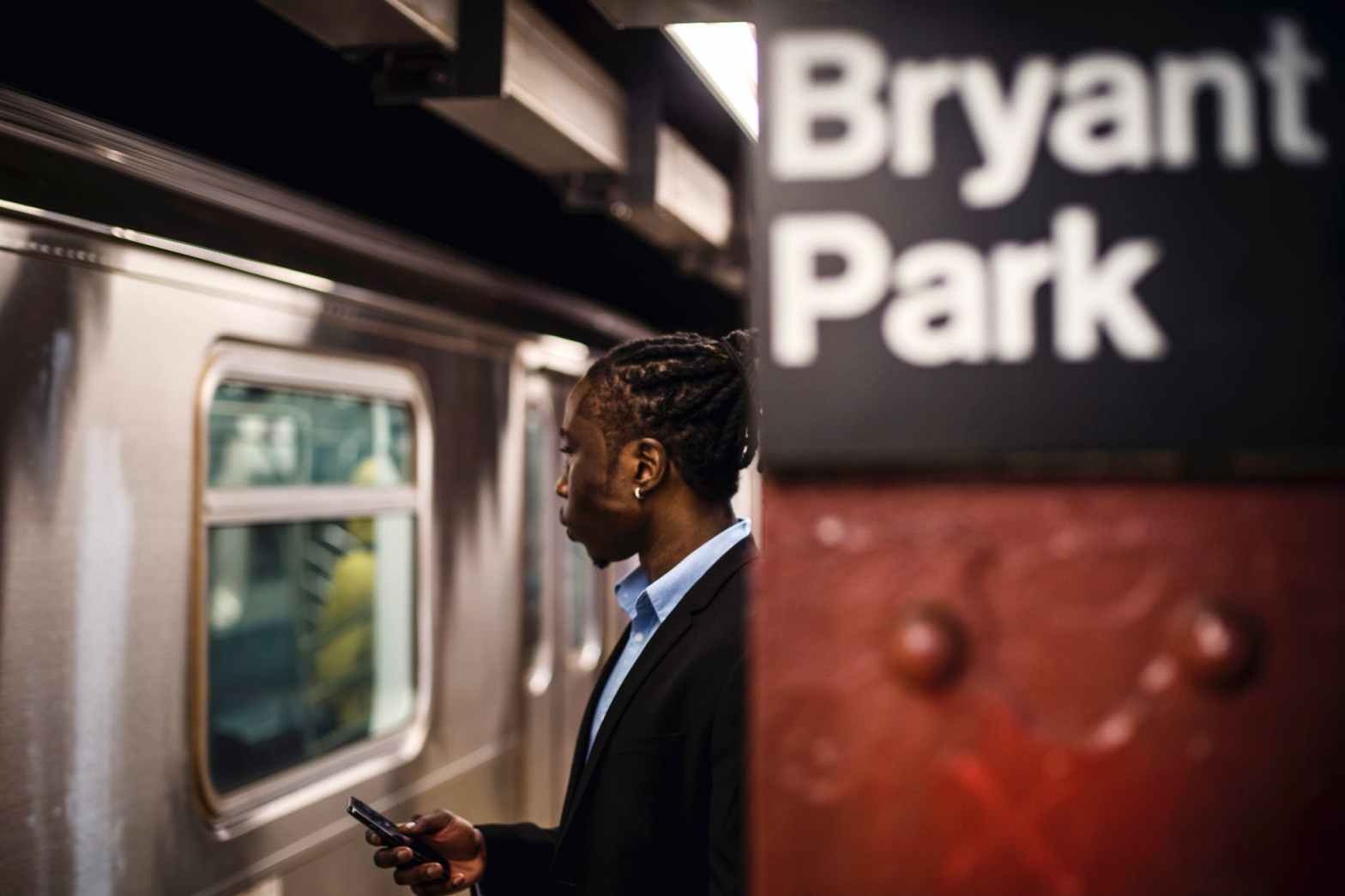 serious man with smartphone on new york subway